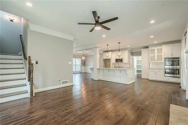 875 Soaring Cir, Marietta, GA 30062 - unfurnished living room with crown molding, a ceiling fan, dark wood-style flooring, recessed lighting, and stairs