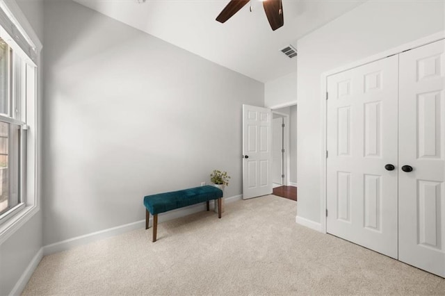 living area featuring ceiling fan and light colored carpet