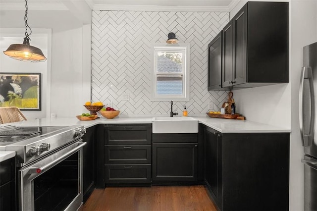 kitchen with appliances with stainless steel finishes, ornamental molding, sink, decorative light fixtures, and dark hardwood / wood-style floors