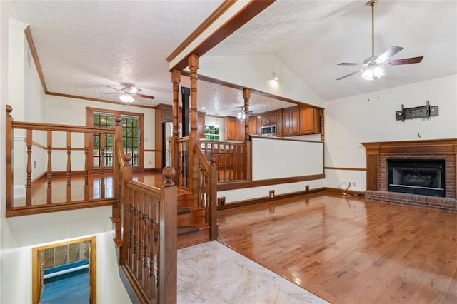 48 Saddle Field Cir NW, Cartersville, GA 30121 - unfurnished living room featuring ceiling fan, a textured ceiling, a fireplace, lofted ceiling, and light wood-style floors