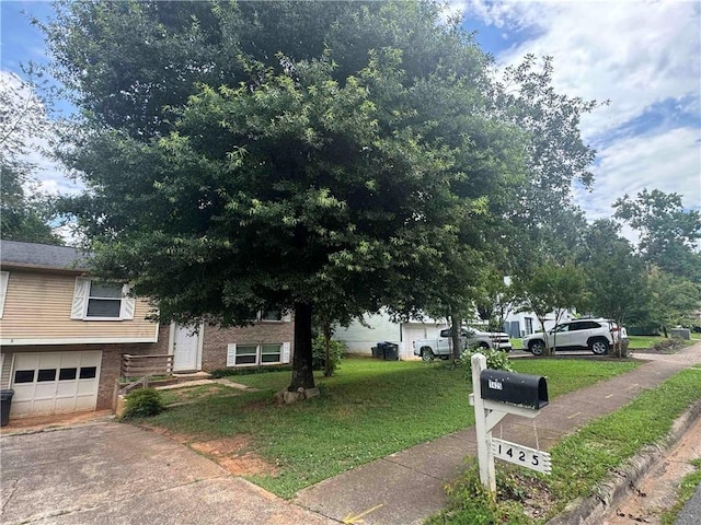 view of front of property featuring an attached garage, a front yard, concrete driveway, and brick siding