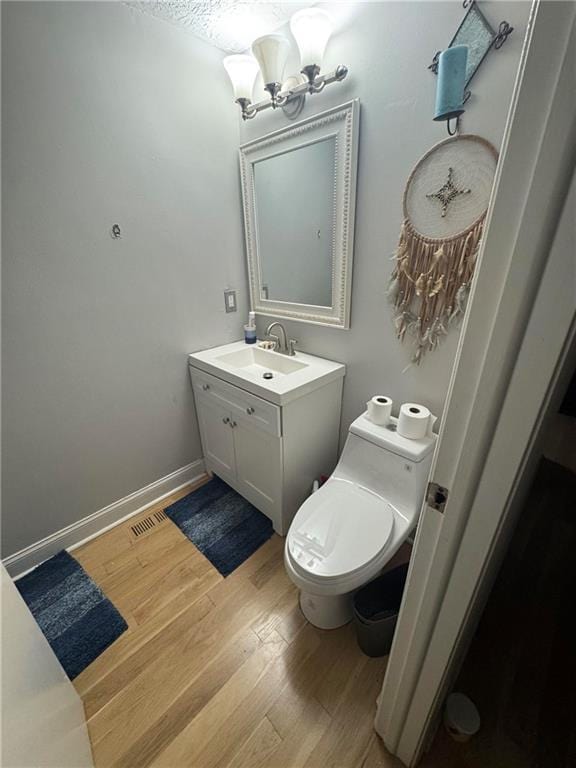 bathroom with a chandelier, wood finished floors, and vanity