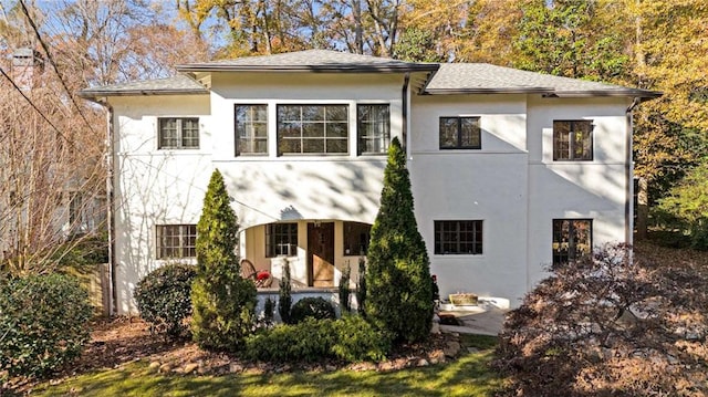 rear view of property featuring stucco siding