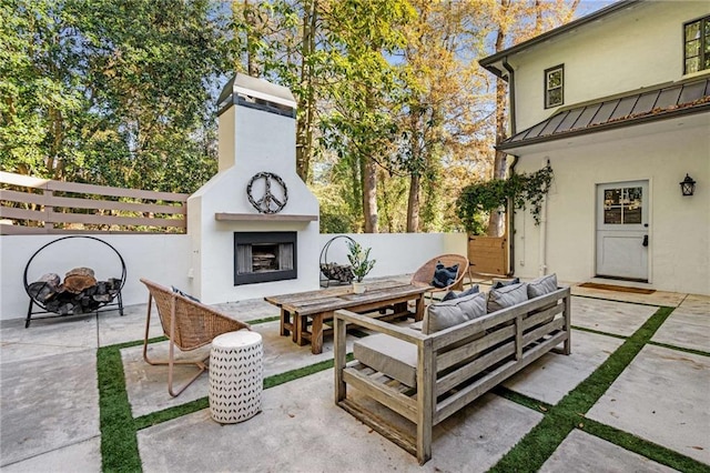 view of patio with an outdoor living space with a fireplace, fence, and outdoor dining area