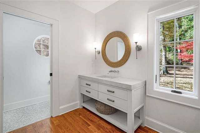 bathroom featuring a wealth of natural light, wood finished floors, vanity, and baseboards