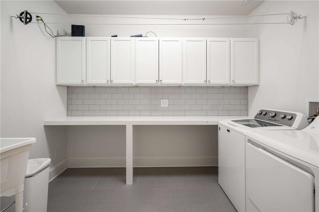 laundry area featuring tile patterned flooring, washing machine and clothes dryer, and cabinet space