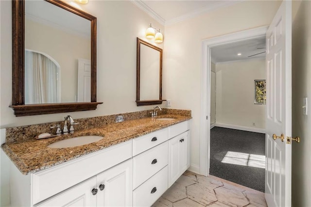 bathroom featuring crown molding, a sink, baseboards, and double vanity