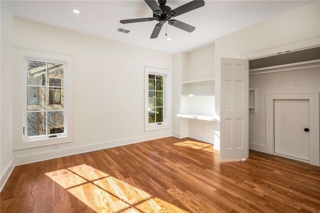 unfurnished room with a barn door, electric panel, and light wood-type flooring