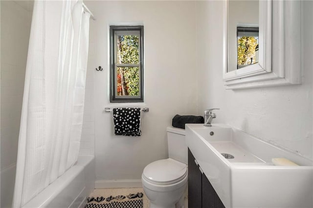 bathroom featuring toilet, vanity, a wealth of natural light, and baseboards