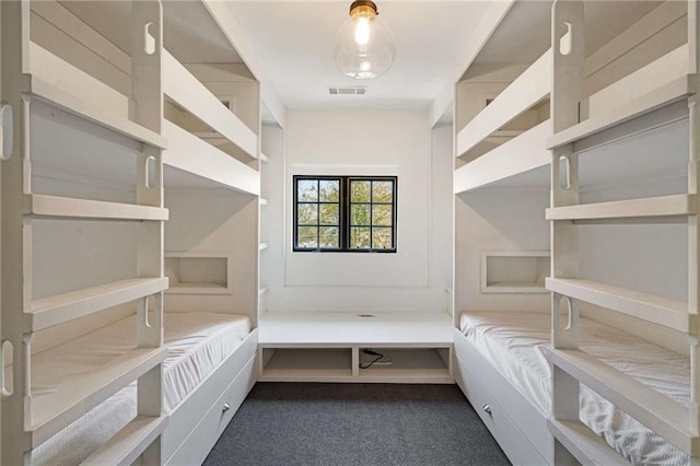 spacious closet featuring dark colored carpet and visible vents