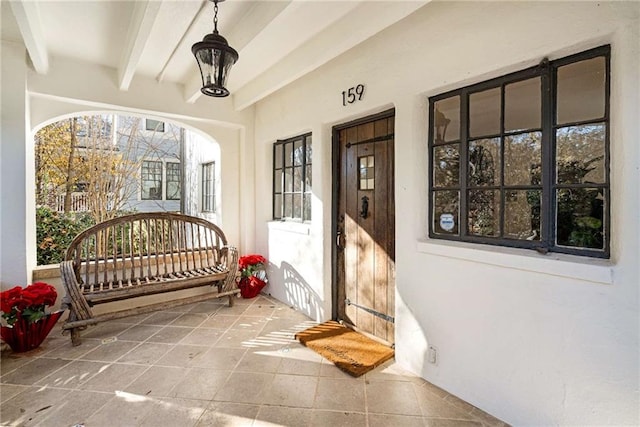 property entrance featuring a porch and stucco siding