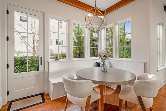 sunroom with beamed ceiling and an inviting chandelier