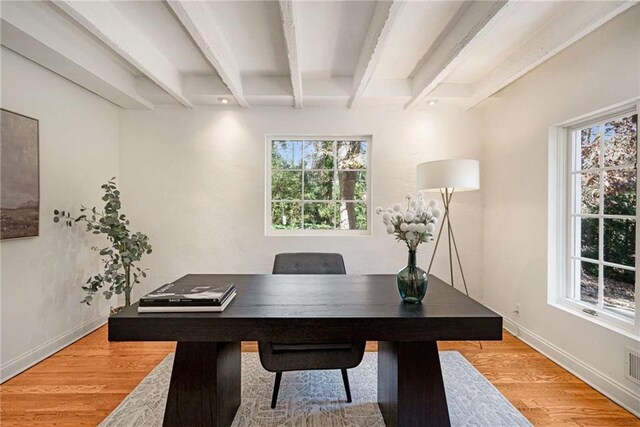 home office with hardwood / wood-style flooring, a barn door, and beam ceiling