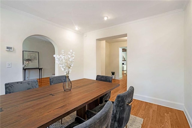 office area featuring baseboards, crown molding, arched walkways, and wood finished floors