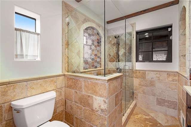 full bathroom featuring tile walls, toilet, wainscoting, a shower stall, and vanity