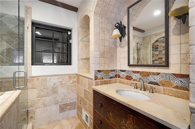 bathroom with walk in shower, vanity, and tile walls