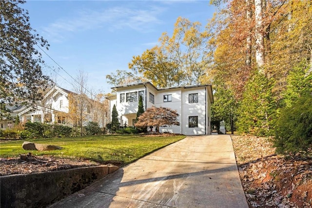 view of front of home featuring stucco siding and a front yard