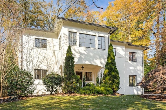 view of side of home with a lawn and stucco siding