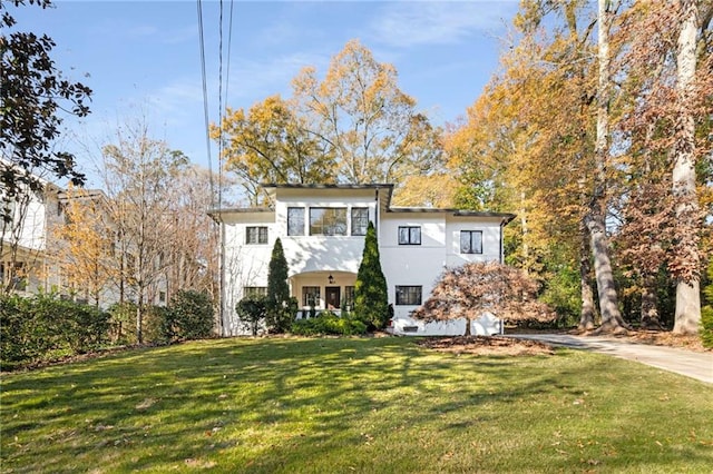 view of front of home with stucco siding, concrete driveway, and a front yard