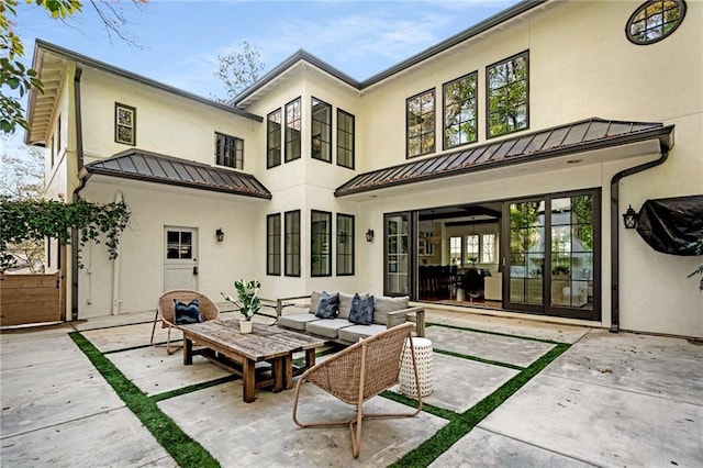 rear view of house featuring a standing seam roof, metal roof, an outdoor hangout area, and french doors