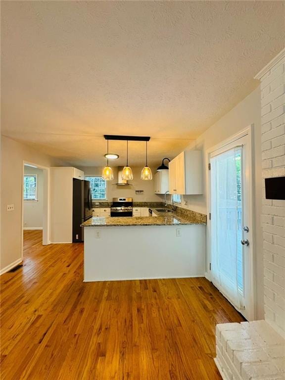 3210 Ebenezer Rd, Marietta, GA 30066 - kitchen featuring electric stove, freestanding refrigerator, a peninsula, a textured ceiling, and wood finished floors