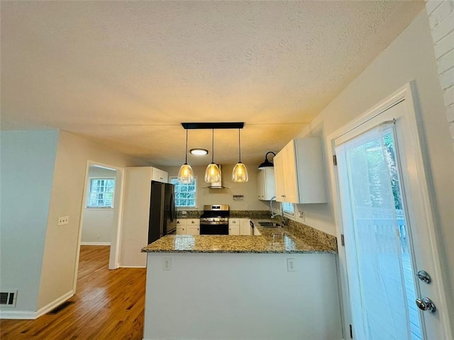 3210 Ebenezer Rd, Marietta, GA 30066 - kitchen with stainless steel gas stove, freestanding refrigerator, a sink, a peninsula, and dark stone countertops