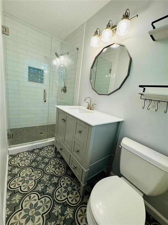 3210 Ebenezer Rd, Marietta, GA 30066 - full bath featuring toilet, tile patterned floors, a shower stall, and vanity