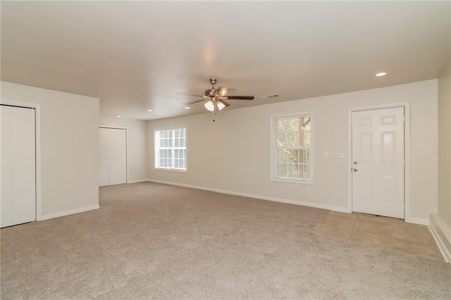 carpeted spare room featuring ceiling fan