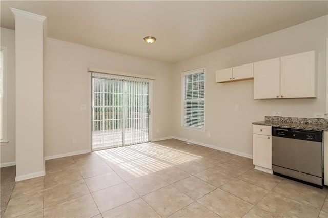 kitchen with white cabinets, stainless steel dishwasher, dark stone countertops, and light tile patterned floors