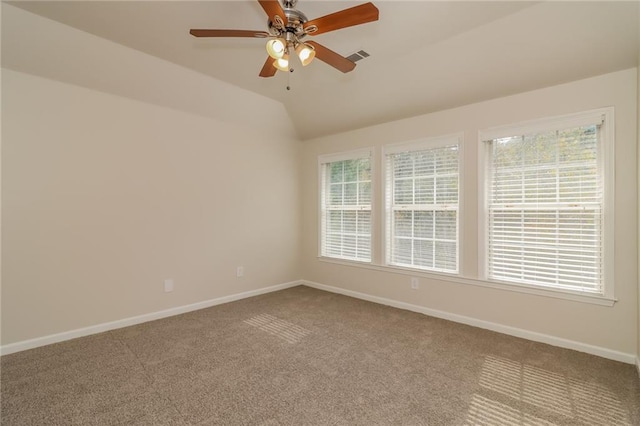 carpeted empty room featuring plenty of natural light, lofted ceiling, and ceiling fan