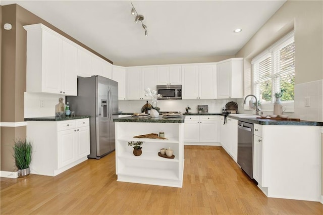 4963 Kingsbridge Ct, Powder Springs, GA 30127 - kitchen with stainless steel appliances, a sink, open shelves, and light wood-type flooring