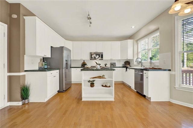 4963 Kingsbridge Ct, Powder Springs, GA 30127 - kitchen with stainless steel appliances, dark countertops, open shelves, and light wood-style flooring