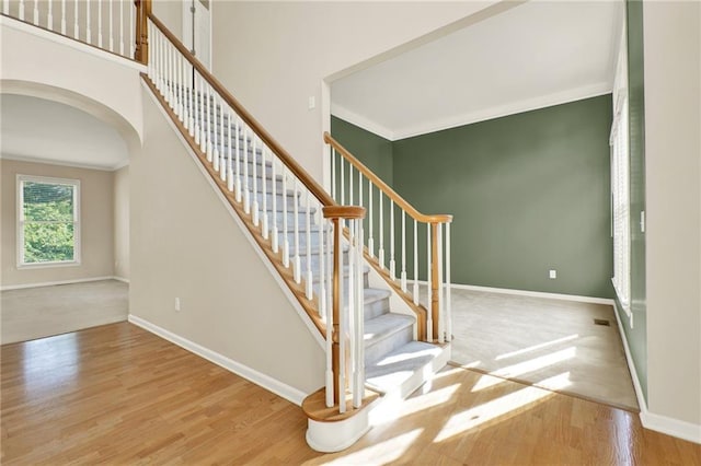 4963 Kingsbridge Ct, Powder Springs, GA 30127 - stairway featuring arched walkways, wood finished floors, crown molding, and baseboards