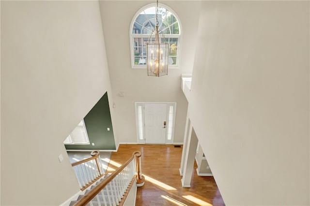 4963 Kingsbridge Ct, Powder Springs, GA 30127 - entrance foyer featuring a towering ceiling, a chandelier, wood finished floors, and baseboards