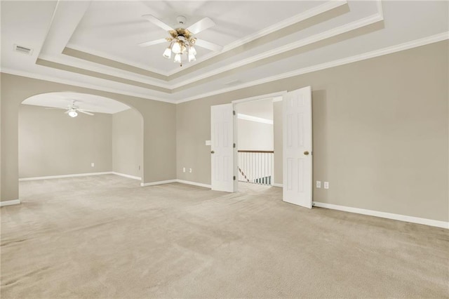 4963 Kingsbridge Ct, Powder Springs, GA 30127 - spare room featuring a ceiling fan, a tray ceiling, arched walkways, ornamental molding, and light carpet
