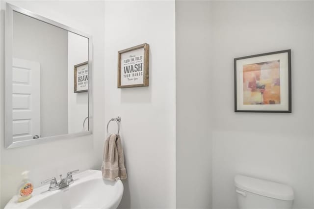 half bathroom featuring a sink and toilet