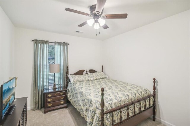 bedroom featuring light carpet, a ceiling fan, visible vents, and baseboards