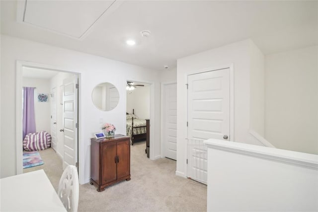 corridor with baseboards and light colored carpet