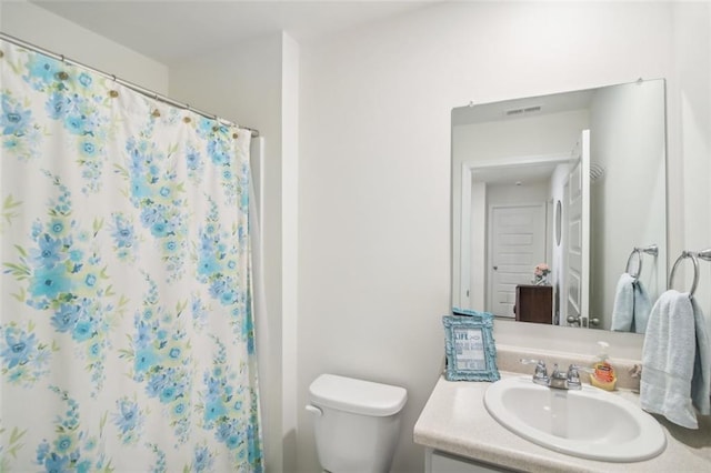 bathroom with toilet, curtained shower, visible vents, and vanity