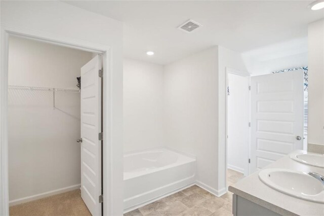 bathroom featuring a tub to relax in and vanity