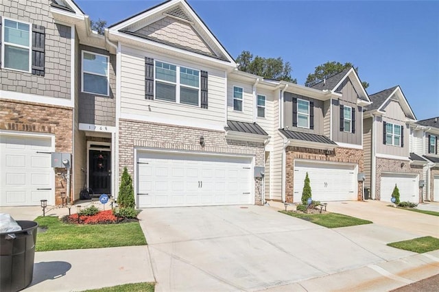 townhome / multi-family property with brick siding, an attached garage, a standing seam roof, metal roof, and driveway