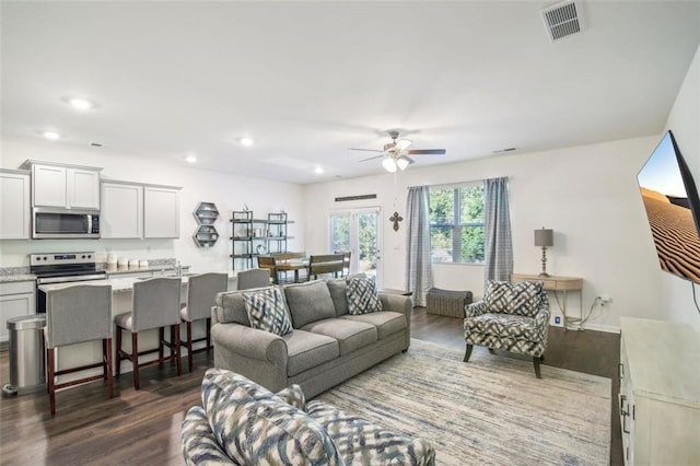 living room with ceiling fan, dark wood-type flooring, visible vents, and recessed lighting