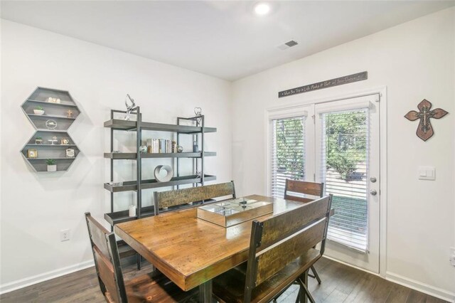 dining area with dark wood-style flooring, visible vents, and baseboards