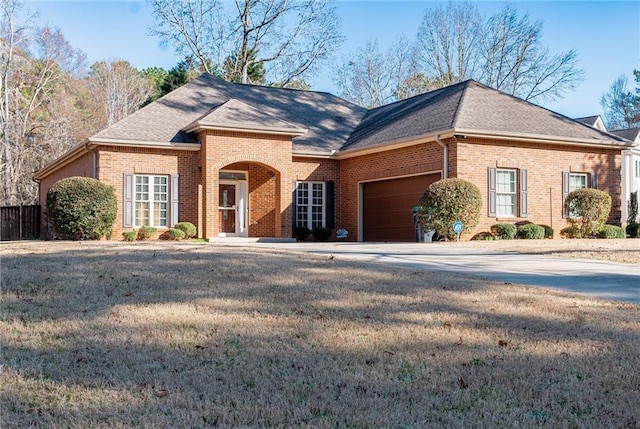 view of front of property featuring a garage, brick siding, and roof with shingles