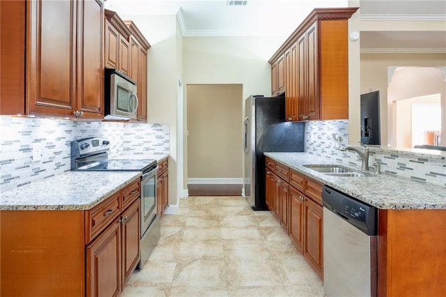 kitchen with light stone countertops, ornamental molding, stainless steel appliances, and a sink