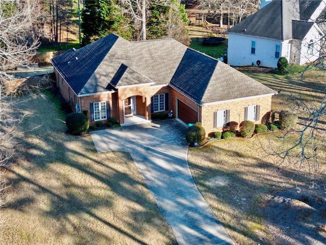 exterior space featuring a garage, driveway, and brick siding