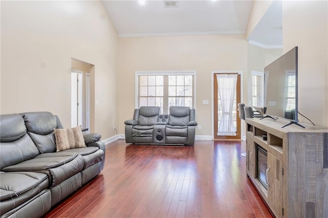 living room featuring crown molding, a high ceiling, dark wood finished floors, and baseboards