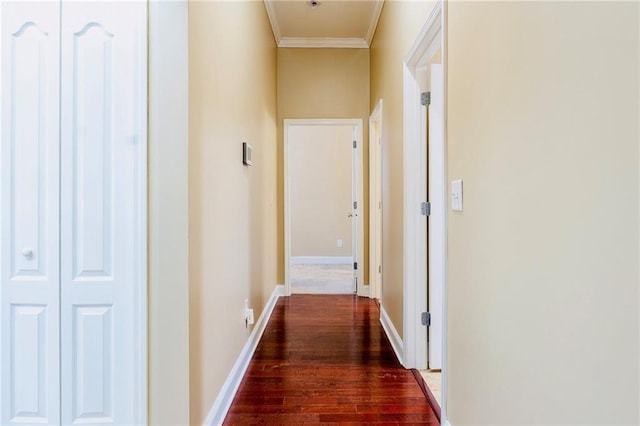 hall with ornamental molding, wood finished floors, and baseboards