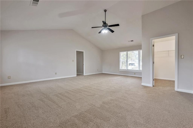 carpeted spare room with ceiling fan and vaulted ceiling