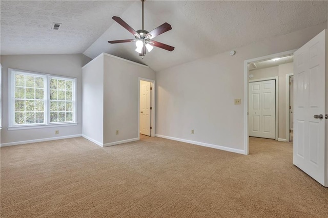 unfurnished room with ceiling fan, a textured ceiling, light carpet, and lofted ceiling